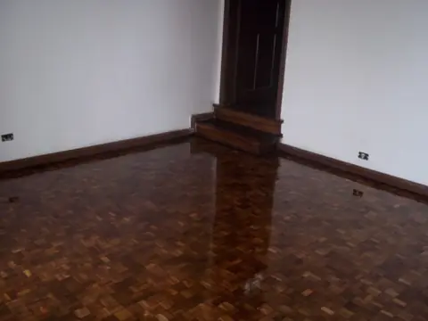 Sala com piso de tacos escuros de alto brilho